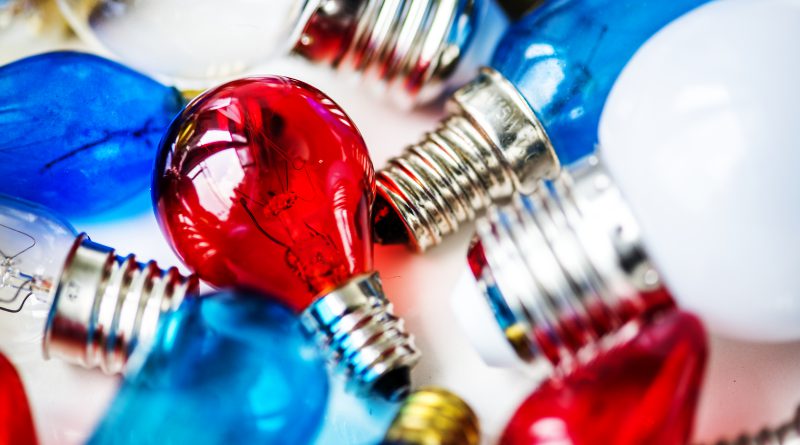 Zbliżenie na kolorowe żarówki z widocznymi gwintami, będące przykładem ozdobnych art elektrycznych