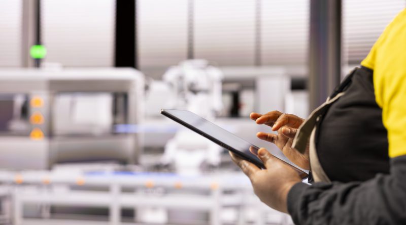 Pracownik hali produkcyjnej korzystający z tabletu do zarządzania automatyzacją poprzez mobilny system kontroli produkcji kraków.